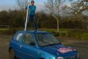 Flying the flag: Elena Sikdar on the roof of their Nissan rally car
