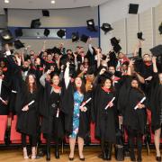 Uxbridge College and Harrow College HNC & HND achievers celebrate their graduation at Brunel University London with the traditional custom of throwing their mortar boards in the air.