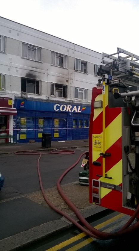 Fire crews tackle blaze in flat above row of shops