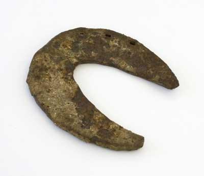 Broad horseshoe - a flat metal plate nailed to the base of a horse's hoof for its protection - this example is 4cm wide at its widest point.

The game of horseshoes involved tossing horseshoes at a stake in the ground.
