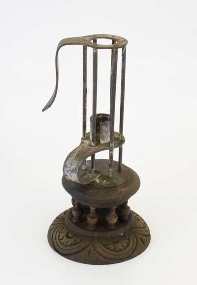 Iron candlestick with an ornate wooden base, probably 18th Century, from Harefield Place. The ancient Manor of Harefield dates back to 1446 and was property of the Newdigate family. The old Manor house, Harefield Place, was burnt down in the 17th Century.
