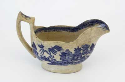 Early 19th Century sauce boat decorated with blue and white willow pattern. The term Willow is applied in a general way to many of the copies of the blue-and-white porcelain imported into England from China during the last half of the 18th century.