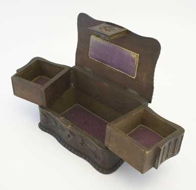 The upper part of the box is in two halves hinged to swing outwards revealing the lower section, with a purple silk lining. Victorians loved jewellery and ladies would keep their jewellery box on a chest of drawers in their bedrooms.
