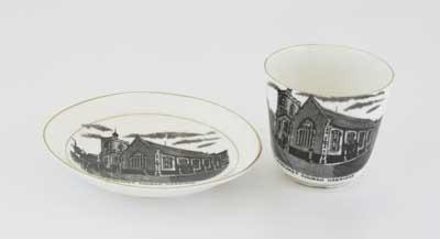 White cup and saucer with depiction of 'St Margaret's Church, Uxbridge'. Marked 'made for Chas. Hall, China Merchant, Uxbridge'. It is believed that Charles Hall's china business was the oldest in Uxbridge operating for nearly a century.