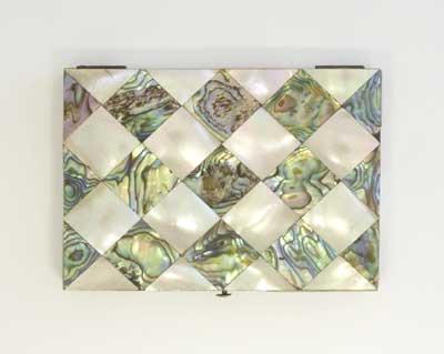 Decorated with diamond pattern of mother-of-pearl and abalone shell. Inside there is nine compartments to hold the cards in blue material. Visiting and leaving cards was an important activity for the upper classes during the Victorian period. 