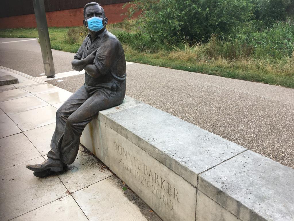 A facemask covering the Ronnie Barker statue outside the theatre in August 2020